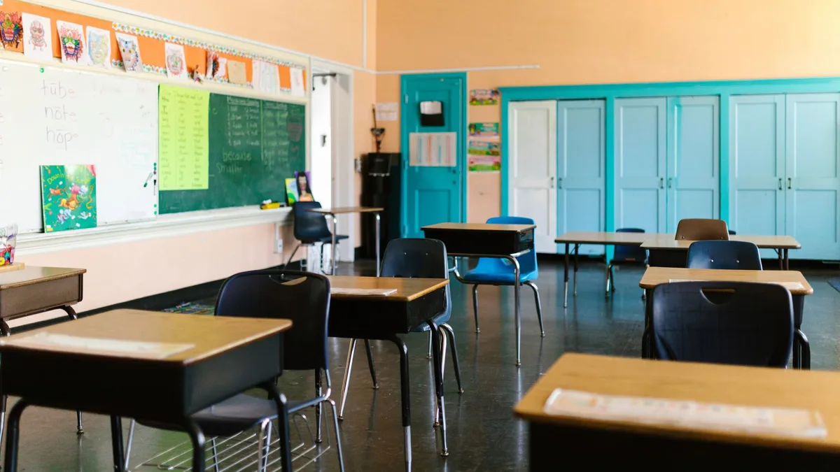 Bright and colorful empty classroom with desks, blackboard, and educational materials.