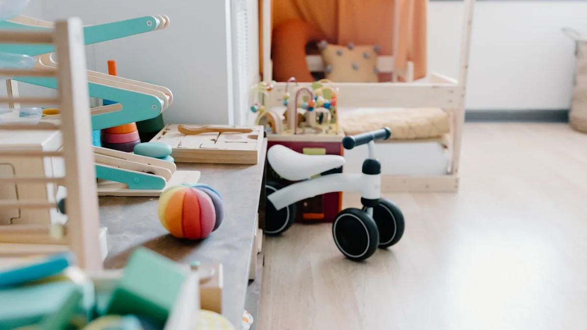 Bright and minimalistic children's playroom featuring wooden toys and balance bike for sustainable learning.